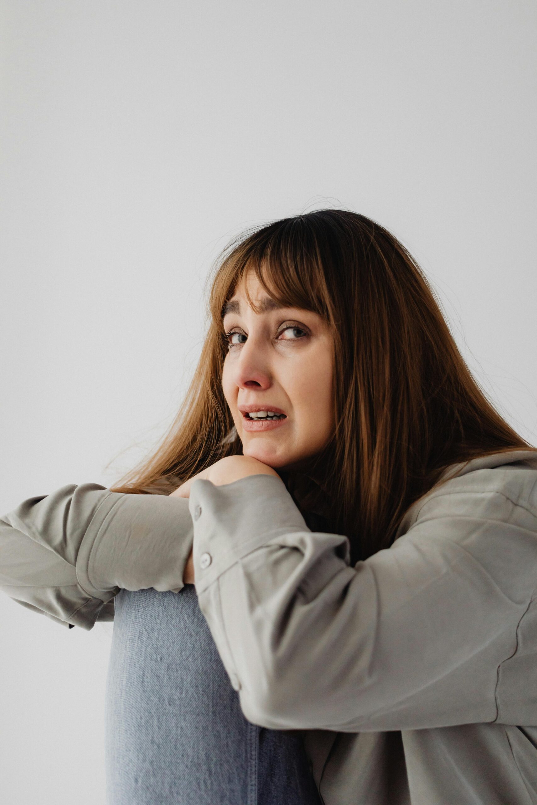 Angstige vrouw met tranen en symptomen van een paniekaanval die troost en rust zoekt.