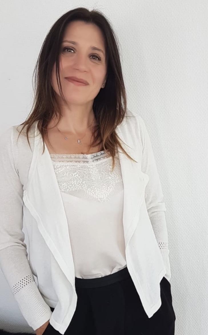 Portret van Géraldine Auguste, holistisch therapeut en kinesioloog in witte kleding, illustratie voor de sectie 'Wat je kunt verwachten' en de start van een behandeltraject bij Mindful Living Therapeutics.