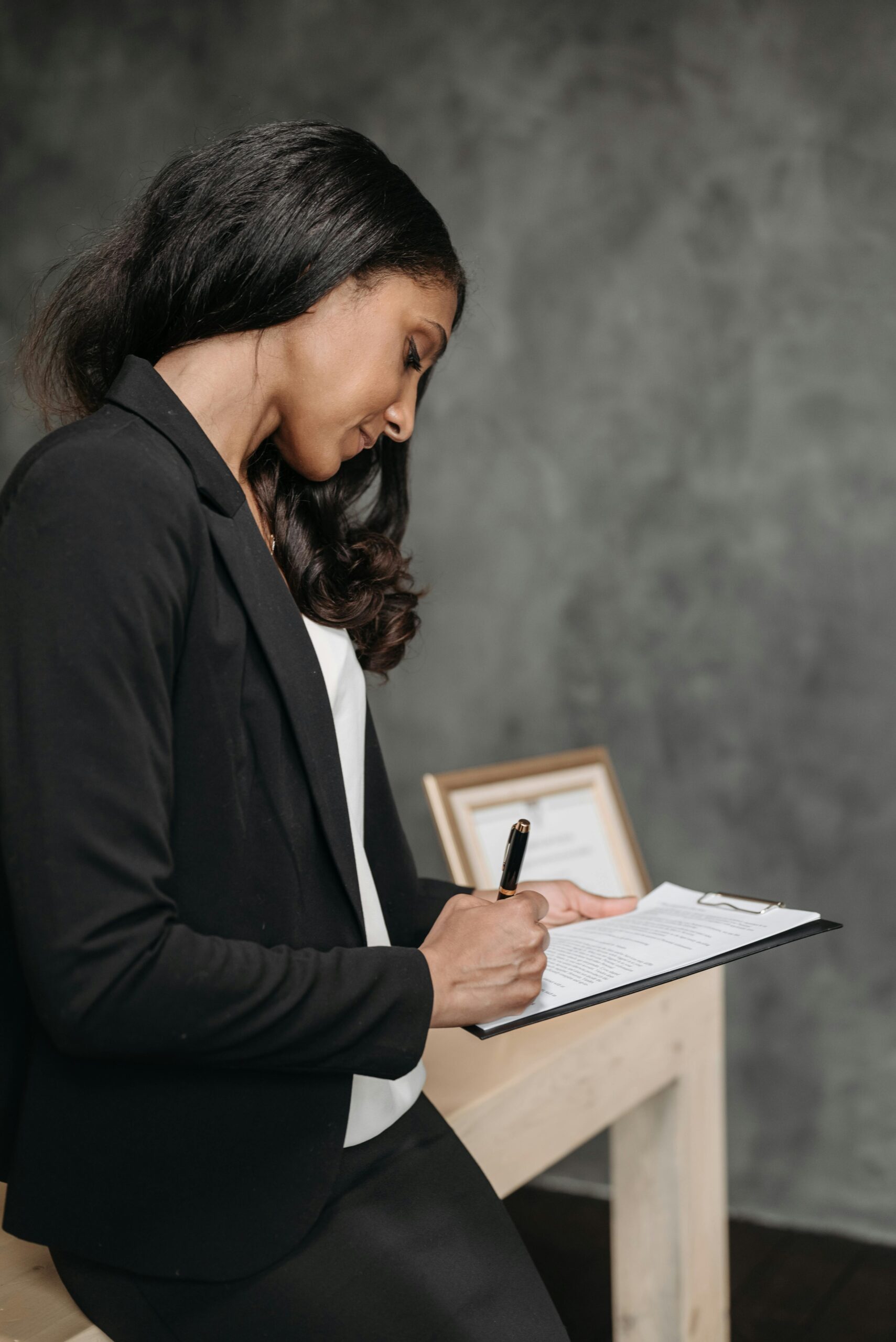 pro-trajecten-holistische-aanpak-ziekteverzuim-stress-mindful-living-therapeutics Serieuze vrouw werkt met focus op kantoor na een traject voor stresspreventie en veerkracht bij Mindful Living therapeutics.